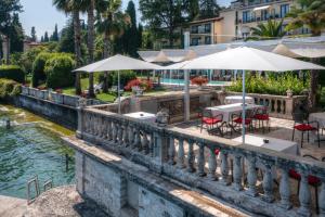 加尔多内-里维耶拉卡普里别墅酒店的河上一座桥,上面有桌子和遮阳伞