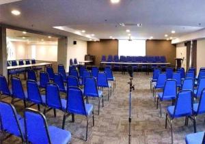 怡保Hotel Pi Ipoh的一间会议室,配有蓝色的椅子和屏幕