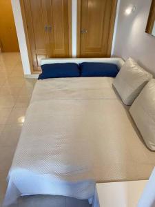 托雷德本纳贾尔邦Costa del Golf的一张大白色的床,里面配有蓝色枕头