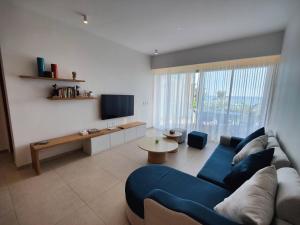 潘托皮芒Ocean Point Beach Front Apartment的客厅配有蓝色的沙发和桌子