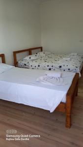 DardhëGuest House Qafe Dardha - Tomorr National Park的配有白色床单的客房内的两张床