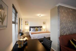 开普敦Rondebosch Central的卧室配有一张床和一张桌子
