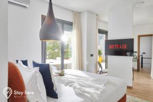 卡萨布兰卡Stayhere Casablanca - Gauthier 2 - Contemporary Residence的卧室配有白色床,墙上挂着睡椅标志