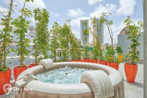 卡萨布兰卡Stayhere Casablanca - Gauthier 2 - Contemporary Residence的屋顶的热水浴池,种植了盆栽植物