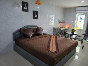 Ban Kut Ngongกานต์สินี อินน์ รีสอร์ท的一间卧室配有一张床和一张桌子及椅子
