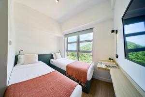 香港South Nest的带窗户的客房内的两张床