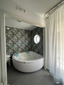索伦托Hotel Tasso Suites & Spa的带浴缸的浴室和墙壁