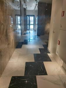 PromyshlennyyКвартира ЖК Балкадиша的走廊铺有黑白瓷砖地板。