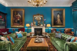 伦敦The Gore London - Starhotels Collezione的客厅设有蓝色的墙壁和绿色的沙发。
