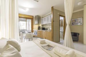 夸尔图-圣埃莱娜Ice Apartment - Free Wifi的一间带白色床的卧室和一间厨房