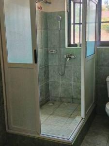 姆巴拉拉3-Bedroom Mbarara Apartment with Optional Farm Tour的浴室里设有玻璃门淋浴