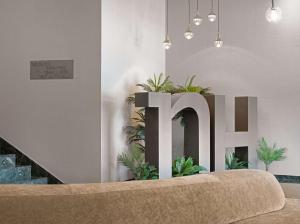 昆卡NH昆卡城市酒店的一间大写字母h和植物的房间