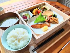 鸟栖市绿色丰富鸟栖站前酒店的桌上的盘子,包括寿司和米饭