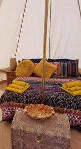 GüimeThe Tent的两张带黄色枕头的床和客房内的行李箱