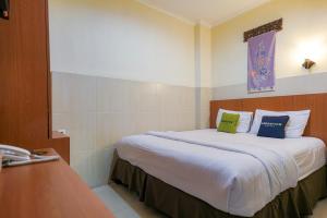 PondoklangUrbanview Hotel 58 Bintaro by RedDoorz的酒店客房 - 带一张大床和两个枕头