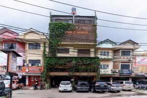 PondoklangUrbanview Hotel 58 Bintaro by RedDoorz的前面有汽车停放的建筑