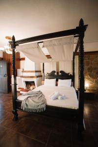 帕莱斯潘蒂雷蒙Pliades Traditional Guesthouse的一间卧室配有一张带毛巾的天蓬床。