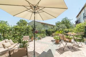 MonterosiGinevra Home的一个带桌子和遮阳伞的庭院
