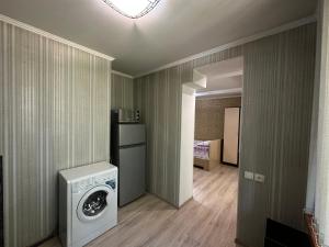 (( Turksib ))Однокомнатная квартира напротив Аэропорта Алматы的洗衣房配有洗衣机和烘干机