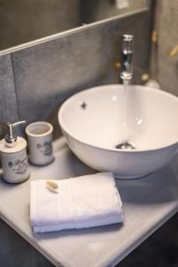 古维亚Dalie Luxury Suites的一间带水槽和白色毛巾的浴室