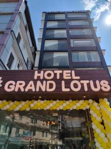 迪马普尔Hotel Grand Lotus的黄色气球的酒店大楼标志