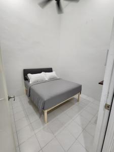 丰盛港4 bedroom homestay @ Mersing的白色客房内的一张床铺,