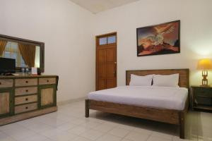 日惹RedDoorz at Griya Cemara Homestay Yogyakarta的一间卧室配有一张床和一个梳妆台