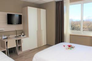 蒙卡列里达斯娜最佳品质酒店的酒店客房设有一张床、一张书桌和一台电视机。