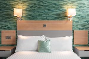 阿勒浦加里东尼亚订制酒店的一间卧室,床上方有两盏灯