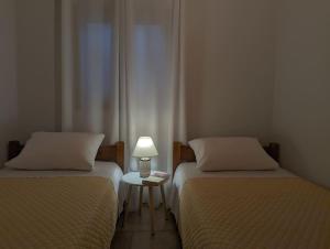 依拉佩特拉Santa Maria - Seaside Serenity的一张桌子上灯的房间里两张床铺