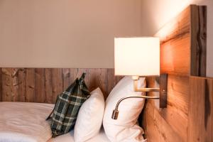 伯布林根族瑞特酒店及餐厅的一间卧室配有一张带台灯和枕头的床