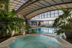 特拉维夫特拉维夫海滩皇冠假日酒店的一座大型游泳池,位于一座带大型室内游泳池的建筑内
