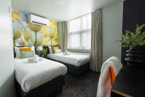 阿姆斯特丹马尔塔图里酒店的酒店客房设有两张床和窗户。