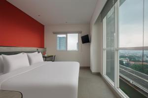 雅加达Amaris Hotel Kalimalang的卧室设有白色的床和大窗户