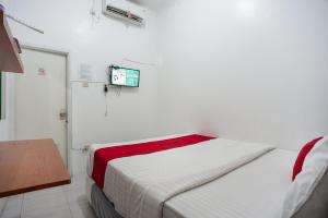 雅加达RedDoorz Syariah near PGC Cililitan的卧室配有一张床,墙上配有电视。