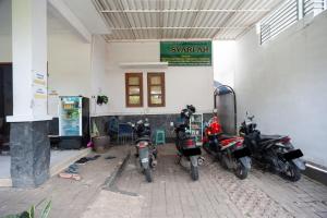 雅加达RedDoorz Syariah near PGC Cililitan的停在大楼前的一组摩托车