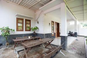 雅加达RedDoorz Syariah near PGC Cililitan的一间设有两张木桌和长椅的房间