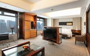 佛山佛山保利洲际酒店-广交会免费穿梭巴士的酒店客房设有电视和床。