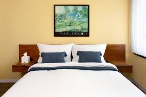 科隆里吉纳加尼科隆酒店的一间卧室配有白色床和蓝色枕头