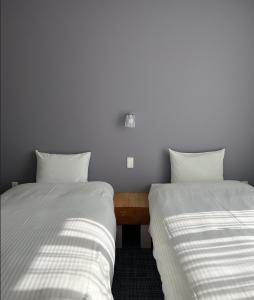 富良野AIR FURANO的两张睡床彼此相邻,位于一个房间里