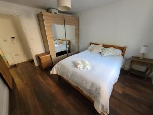 伦敦Comfortable Two Bedroom Modern Apartment的卧室配有一张白色大床和镜子