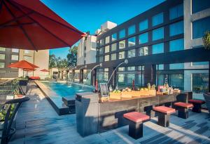 印多尔印多尔万豪酒店的一座带酒吧和桌子的游泳池以及一座建筑