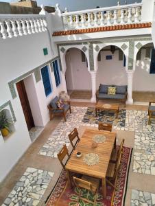 Ouled YanegBeit El Ezz - la grande的客厅配有木桌和椅子