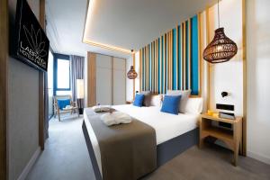 阿德耶Labranda Suites Costa Adeje的酒店客房配有一张带蓝色枕头的大床