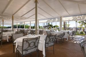 奇克拉纳－德拉弗龙特拉巴罗萨皇宫酒店的餐厅配有桌椅和白色桌布