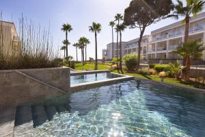 奇克拉纳－德拉弗龙特拉巴罗萨皇宫酒店的棕榈树建筑中的游泳池