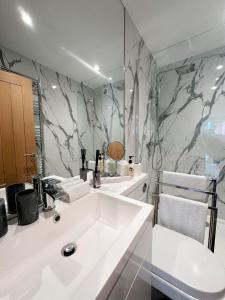 诺里奇2 Southwell Road - Luxurious City Centre Apartments的浴室配有白色水槽和大理石墙