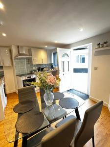 诺里奇2 Southwell Road - Luxurious City Centre Apartments的厨房配有桌椅和花瓶