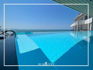 都拉斯Luxury Rooftop Suites by Blumont的大楼内的一个蓝色海水游泳池