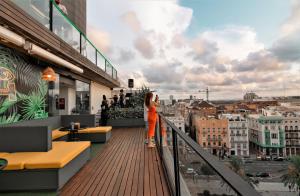 瓦伦西亚Sea You Hotel Port Valencia的站在一个眺望城市的阳台上的女人